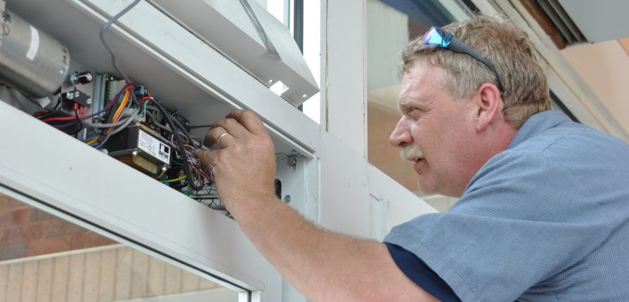 Photo of a technician working inside of an automatic door header