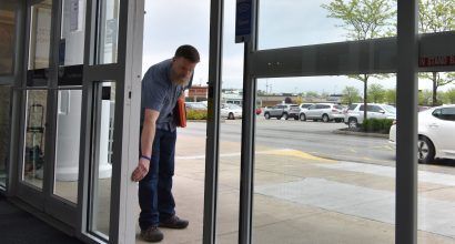 Photo of a door technician performing a safety check on a sliding door